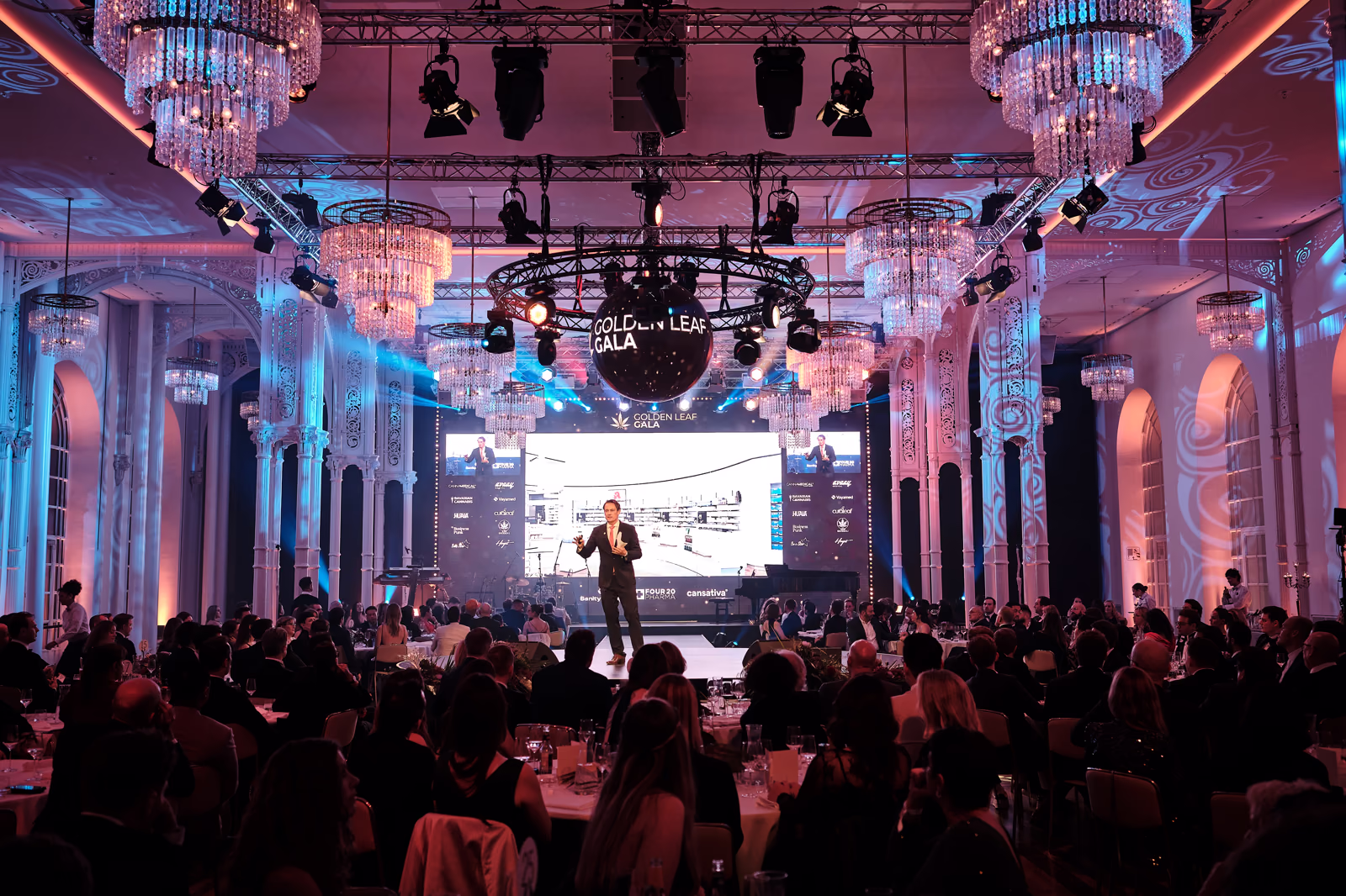 Der volle Festsaal der Flora bei einer Abendgala: Kronleuchter, Lichtshow und die raumbreite LED-Wand hinter der Bühne